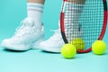 Isolated Closeup on Legs of Caucasian Female Tennis Player Grasping Tennis Ball With Racket. Over Blue Royalty Free Stock Photo