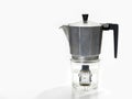 Isolated closeup shot of a watch in water in a Moka pot coffee machine with a glass bottom