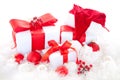 Isolated closeup shot of white Christmas gift boxes with red bows next to Christmas tree ornaments Royalty Free Stock Photo