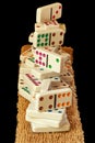 Isolated closeup with stacked dominoes piled high on a brown mat.