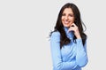 Isolated closeup studio portrait of happy young woman, smiling broadly, wears blue long sleeve blouse, posing on white wall. Royalty Free Stock Photo