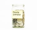 Isolated coins in jar with please donate label