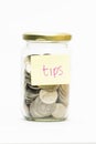 Isolated coins in jar with tips label Royalty Free Stock Photo