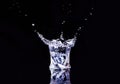 Isolated cold water in a glass with splash and cubes of ice on black background Royalty Free Stock Photo