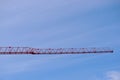 isolated construction tower crane boom. red steel truss structure. blue sky. Royalty Free Stock Photo