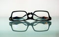 Isolated corrective vision glasses in abstract frontal view. Strong reflection. White background.