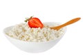 Isolated cottage cheese with a strawberry and the wooden spoon in a bowl