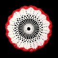 Isolated crocheted decorative white doily with red border on a black background. Round volumetric doily