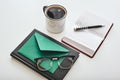 Shot of minimalistic work desk. Isolated cup of coffee, envelope, pen, notebooks and glasses lying on a white background Royalty Free Stock Photo