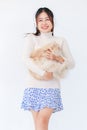 Isolated cutout studio shot Asian young pretty sexy female teenager girl model in turtleneck sweater standing holding cute little Royalty Free Stock Photo