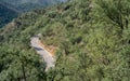 Isolated cyclist climbing mountain curved road