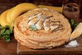 isolated desert - stack of pancake with chocolate spread and banana on a wooden table