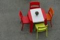 Isolated deserted red cafe table and chairs on gray rustic floor