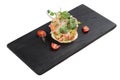 Isolated Diced salmon salad with avocado, tomato, onion, chilli, and coriander served in black rectangle stone plate on washi.