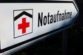 Isolated direction sign with red cross for hospital emergency department german word: Notaufnahme - Germany Royalty Free Stock Photo