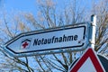 Isolated direction sign with red cross for hospital emergency department german word: Notaufnahme - Germany