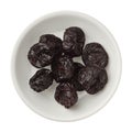 Isolated dried plums in a bowl over white background