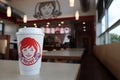 Isolated drinking cup at a Wendy\'s restaurant. Out of focus restaurant interior in background.