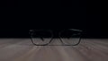 Isolated eyeglasses on a desk. Black, formal, business spectacles for office, computer, work or reading.