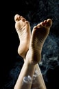 Isolated female feet on black background surrounde