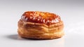 Isolated fresh, ruddy pastry lies on a white glossy surface