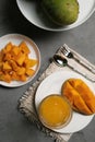 Isolated Glass of Mango Juice with fresh Mango fruit slices on rustic table