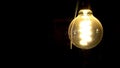 isolated glowing light bulb in a dark room on a black background with a lot of space
