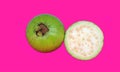 Isolated green guava with white flesh. One half whole fruit isolated on pink background with clipping path
