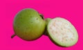 Isolated green guava with white flesh. One half whole fruit isolated on pink background with clipping path