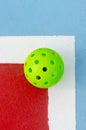 isolated green pickleball ball on a pickleball court line