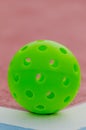 isolated green pickleball ball on a pickleball court line