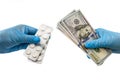 Isolated 2 hands in medical gloves with 100 dollars banknotes and pills on a white background. The concept of corruption or quaran