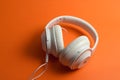 Isolated headphone set on colorful orange background. AI Generated