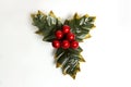 Isolated holly berry with leaves. Plastic, artificial Ilex berries on sprig.