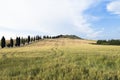 An isolated house and cypresses in a field in Val d`Orcia or Valdorcia, a very popular travel destination in Tuscany, Italy Royalty Free Stock Photo