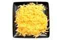 Isolated image of grated hard cheese on a black square plate. Royalty Free Stock Photo