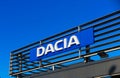 Isolated lettering of rumanian automobile manufacturer Dacia against cloudless blue sky on roof of car dealer