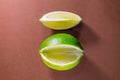 Sliced lime fruits isolated on brown background Royalty Free Stock Photo