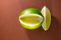 Sliced lime fruits isolated on brown background Royalty Free Stock Photo