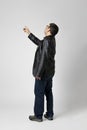 Isolated man on white background is standing with his back turned and pointing to an indefinite point above with his finger