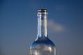 Isolated neck of empty red wine bottle against blue evening sky