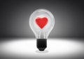Isolated object shot of a light bulb with a heart inside on a dark background Royalty Free Stock Photo