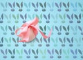 Isolated one easter white egg with pink ribbon on a blue background with a pattern of Bunny rabbit muzzles. Happy Easter holiday Royalty Free Stock Photo