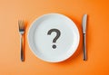 Isolated on an orange background, there is a three-dimensional question mark on a white plate with a fork and knife. This is the Royalty Free Stock Photo