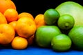 Isolated orange and green color groups citruses fruits on black background. Oranges, tangerines, limes, pummelo, grapefruits on Royalty Free Stock Photo