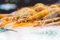 Isolated orange shrimp on ice background on the market, closeup of fresh crustacean products in restaurant, useful shellfish sea