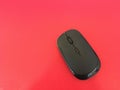 Isolated photo of a black computer mouse on a red background. Royalty Free Stock Photo