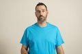 Isolated photo of handsome man with fashionable beard, mustache and hairstyle, wears casual blue t-shirt, poses in