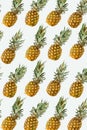 Isolated pineapples pattern or wallpaper on white background. Summer concept of fresh ripe whole pineapples shot from above