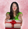 Isolated pink background portrait of young happy and beautiful Asian Chinese woman showing gift box giving or receiving a birthda Royalty Free Stock Photo